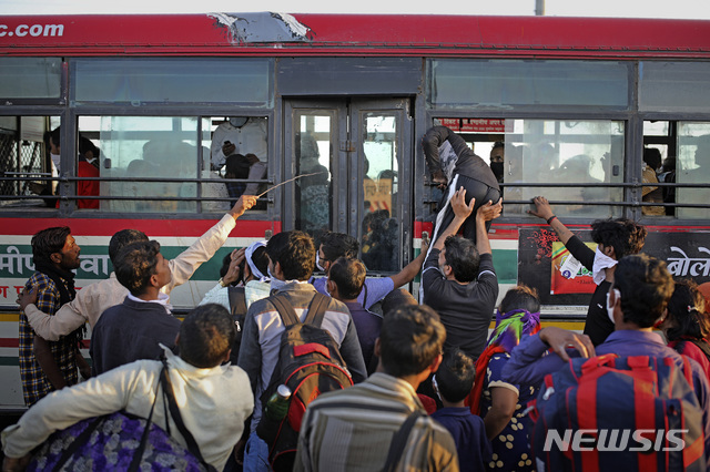 [뉴델리=AP/뉴시스] 지난달 28일 인도 뉴델리의 공영버스정류장에 버스가 들어서자 사람들이 앞다퉈 몰려가고 있다. 신종 코로나바이러스 감염증(코로나19) 확산을 막기 위해 13억 명의 외출을 금지한 인도에서는 도시 빈민 60만명이 대이동을 시작했다. 2020.4.1.