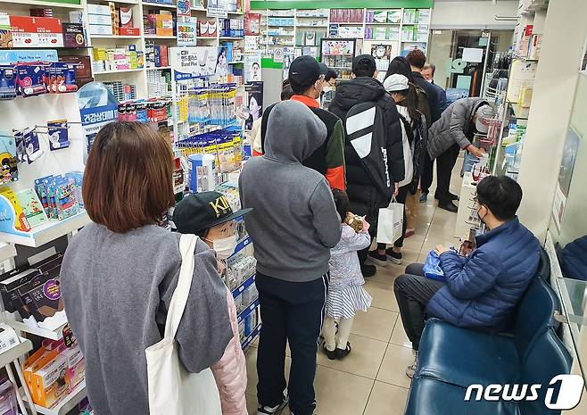 신종 코로나바이러스 감염증(코로나19)이 확산되고 있는 가운데 22일 서울시내 한 약국에 주중에 미처 마스크를 구입하지 못한 시민들이 마스크 구입을 위해 줄지어 서 있다.  © News1 유승관 기자