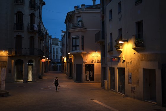 6일 인적이 없는 스페인 이괄라다의 밤거리에 식료품을 든 여성이 텅빈 거리를 걸어가고 있다. [AP=연합뉴스]