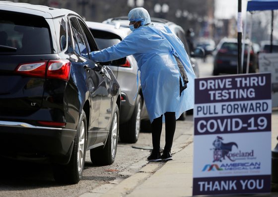 의료진이 미국 시카고에서 신종 코로나 검사를 받기 위해 기다리는 차량 속 운전자와 대화를 나누고 있다. [로이터=연합뉴스]