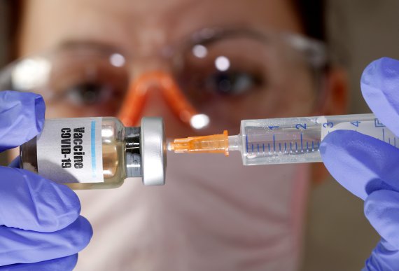 실험실에서 10일(현지시간) 한 연구원이 '코로나19 백신'이라는 스티커가 붙은 병에 주사기를 넣고 있다. 전 세계적으로 코로나19 백신 개발 경쟁이 치열해지고 있는 가운데 영국 옥스퍼드대가 올 9월 백신이 나올 것이라고 밝혔다. 로이터 뉴스1