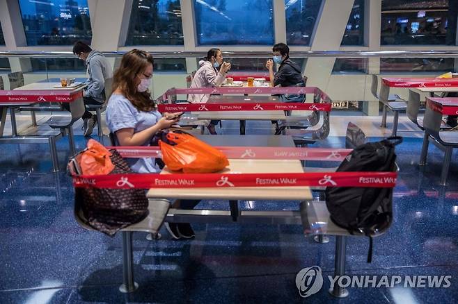 '사회적 거리두기' 동참한 홍콩의 푸드코트 (홍콩 AFP=연합뉴스) 신종 코로나바이러스 감염증(코로나19) 차단을 위한 '사회적 거리두기' 일환으로 테이블과 의자 주변에 빨간 테이프가 둘러진 홍콩의 한 쇼핑몰 안 푸드코트에서 4일(현지시간) 손님들이 앉아 있다. leekm@yna.co.kr