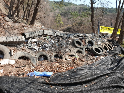 서울 종로구 평창동 425-4일대 공터에 폐타이어와 생활쓰레기가 담긴 마대자루가 쌓여 있다.