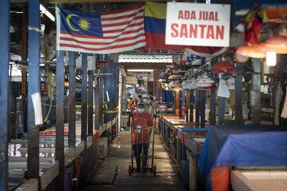 말레이시아의 수도 콸라룸푸르의 한 시장에서 지난달 29일 확진자가 나오자 상인들이 물건을 치우고 있다. 말레이시아에선 지난 3월 18일 전국적인 이동 제한령이 내려져 있다. AP=연합뉴스