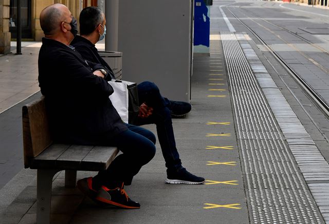 0프랑스 남서부 보르도의 한 트램 역에서 9일 마스크를 쓴 시민들이 앉아 있는 의자 앞에 사회적 거리두기를 유지하기 위한  십자표시가 그려져 있다. 프랑스는 11일부터 전국 봉쇄령을 해제하고 상점과 시장의 영업을 허용한다. 보르도 =AFP 연합뉴스