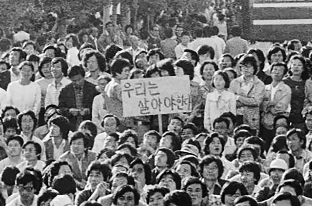 1980년 5월 24일 전남도청 앞 분수대 광장에서 집회가 열리고 있는 가운데 '우리는 살아야 한다'라고 쓴 피켓이 눈에 띈다. 한국일보 특별취재팀