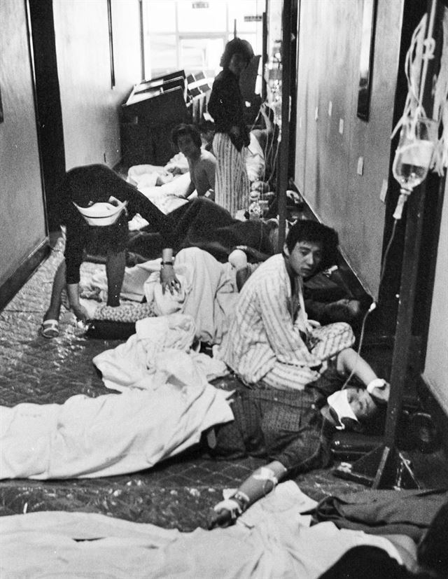 1980년 5월 24일 광주 적십자병원 복도에 누워 있는 부상자들을 간호사가 돌보고 있다. 한국일보 특별취재팀