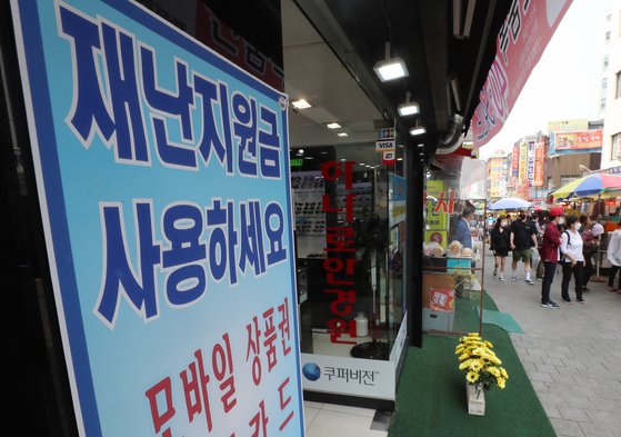 17일 오후 서울 중구 남대문시장 한 상점에 긴급재난지원금 사용 가능 안내문이 붙어 있다. 연합뉴스