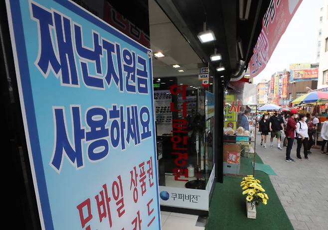 17일 오후 서울 중구 남대문시장 한 상점에 긴급재난지원금 사용 가능 안내문이 붙어 있다. [연합]