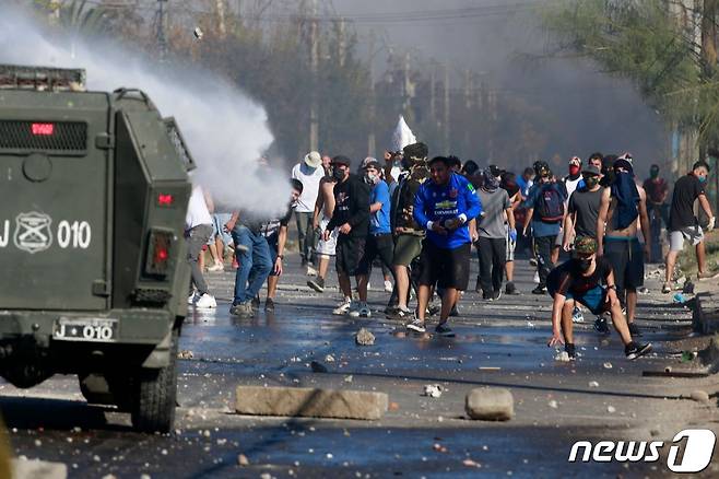 중남미 칠레에서 코로나19 봉쇄가 길어지며 생활고가 가중되자 산티아고 외곽에 있는 빈민가 엘 보스케에서 18일(현지시간) 폭력 사태가 벌어졌다.© AFP=뉴스1