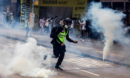 지난 24일(현지시간) 홍콩에서 새로운 보안법 제정안에 반대하는 시위 도중 홍콩 경찰이 시위대에게 최루탄을 발사하고 있다. 홍콩=AFP연합뉴스
