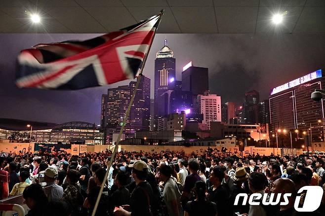 2019년 홍콩 도심에서 시민들이 정부가 입법을 추진하는 중국 본토로의 범죄인 인도 법안이 정치범 탄압 등에 악용될 것이라며 반대하는 대규모 시위가 벌어며 영국 국기를 흔들고 있다. © AFP=뉴스1