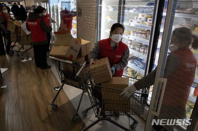 [베이징=AP/뉴시스]18일 중국 베이징의 7프레시 슈퍼마켓에서 이곳 직원들이 냉장고에 제품을 채우고 있다. 지난주 베이징 당국이 춘제 연휴 후 베이징에 돌아온 주민들에 대해 자가 검역을 의무화하면서 주민들의 쇼핑이 줄어 온라인 주문을 제공하는 업체들은 활발한 매출을 올리고 있다. 2020.02.19.