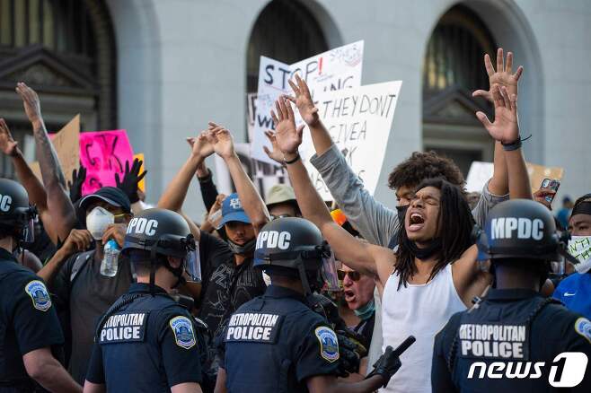 31일(현지시간) 워싱턴DC 백악관 인근에서 '조지 플로이드 사망'에 항의하는 시위가 벌어진 가운데 한 흑인 남성이 경찰들을 향해 소리치고 있다. © AFP=뉴스1