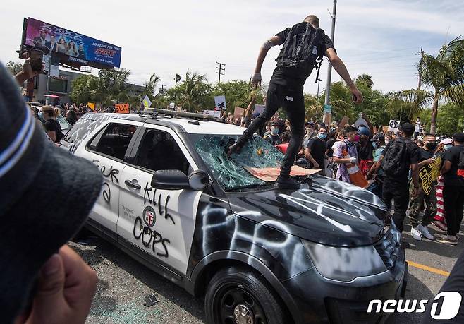 30일(현지시간) 캘리포니아주 로스앤젤레스에서 비무장 흑인 남성 조지 플로이드의 백인 경찰 가혹 행위로 숨진 사건에 항의하는 시위대가 경찰 차량을 파손하고 있다. © AFP=뉴스1 © News1 우동명 기자