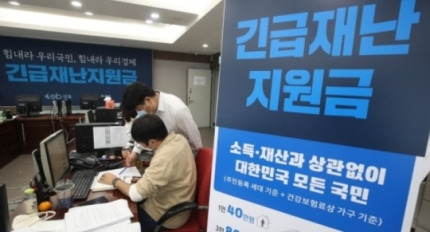 지난달 12일 서울 성북구청에서 직원들이 긴급재난지원금 신청과 관련, 안내와 상담을 하고 있다. [연합]