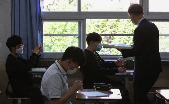 전국연합학력평가가 시행된 지난달 21일 오전 서울의 한 고등학교에서 선생님이 문제지를 나눠주고 있다. 연합뉴스