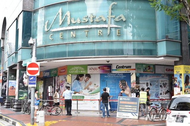 [싱가포르=AP/뉴시스] 지난달 16일(현지시간) 싱가포르 쇼핑몰 무스타파 센터 앞에서 고객들이 신종 코로나바이러스 감염증(코로나19)을 예방하기 위해 사회적 거리두기를 준수하며 줄을 선 모습. 2020.06.02.
