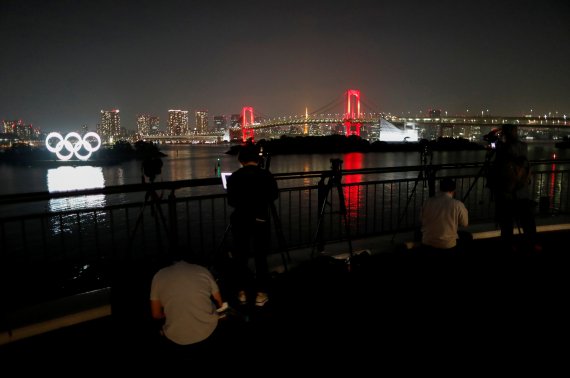 도쿄의 코로나19 감염자 수가 다시 30명대를 기록한 지난 2일 도쿄의 상징인 레인보우 브릿지에 '도쿄 경보'를 알리는 적색조명이 들어왔다. 그 옆으로 도쿄올림픽 로고가 보인다. 로이터 뉴스1