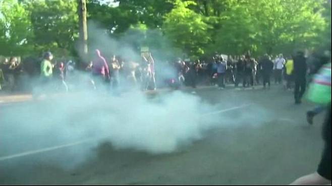 시위대 사이에서 최루 가스를 내뿜는 최루탄
