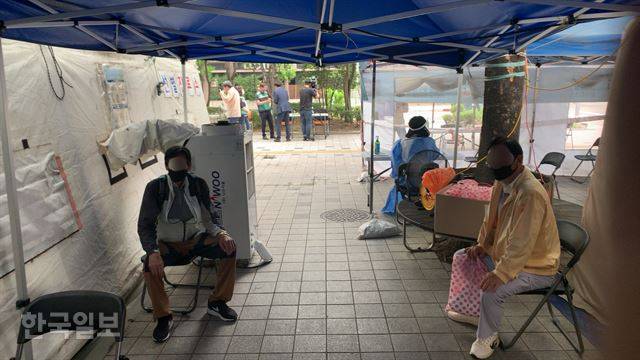 12일 서울 노원구보건소 앞 코로나19 선별진료소 방문객들이 냉방 시설이 열악한 천막 안에서 검체 채취를 위해 대기하고 있다. 김영훈 기자