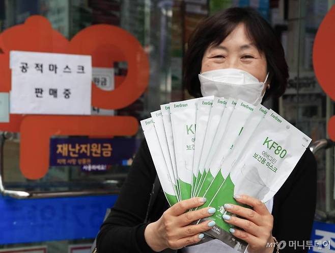 [서울=뉴시스] 박민석 기자 = 공적마스크 구매 수량 한도가 1인당 10개로 확대된 18일 서울 종로구의 한 약국에서 시민이 구매한 마스크를 들고 있다. 2020.06.18.   mspark@newsis.com