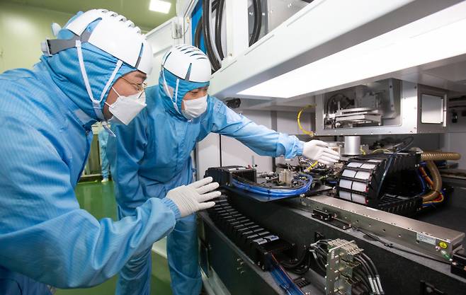 삼성전자 직원(왼쪽)과 장비업체 이오테크닉스 직원이 두 회사가 공동 개발한 반도체 레이저 설비를 살펴보고 있다. 삼성전자 제공