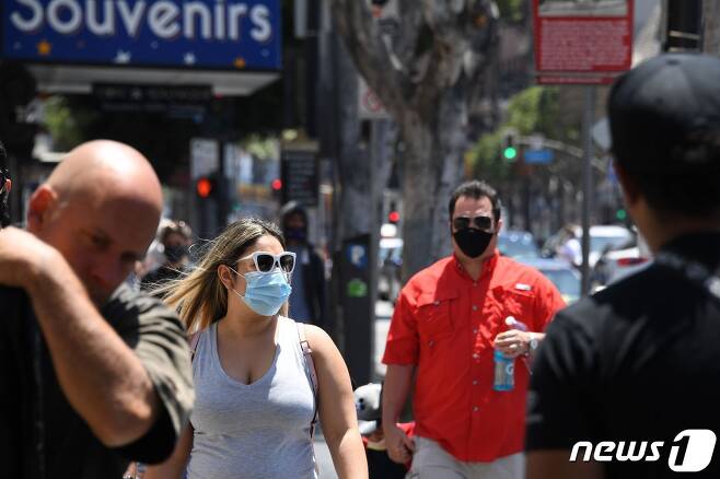 지난달 30일(현지시간) 미국 캘리포니아주 할리우드 명예의 거리에서 마스크를 쓴 주민들이 길을 걷고 있다. © AFP=뉴스1