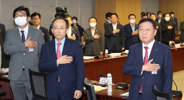 미래통합당 추경호 의원(가운데)과 나재철 금융투자협회장(오른쪽) 등이 2일 오후 서울 여의도 국회에서 열린 바람직한 금융투자세제 개편 방향 긴급 토론회에서 국기에 대한 경례를 하고 있다. 연합뉴스