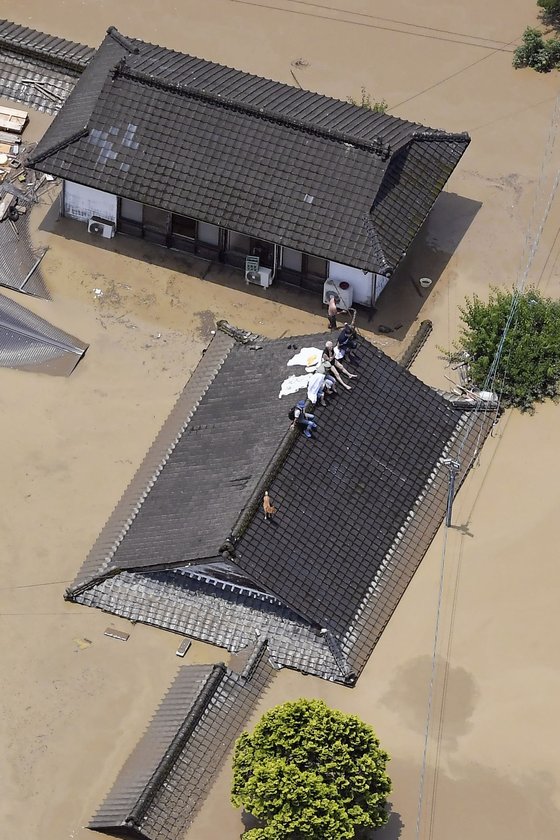 4일(현지시간) 일본 규슈 지방 구마모토현, 히토요시의 한 마을에서 주민들이 구조를 기다리고 있다. AP=연합뉴스