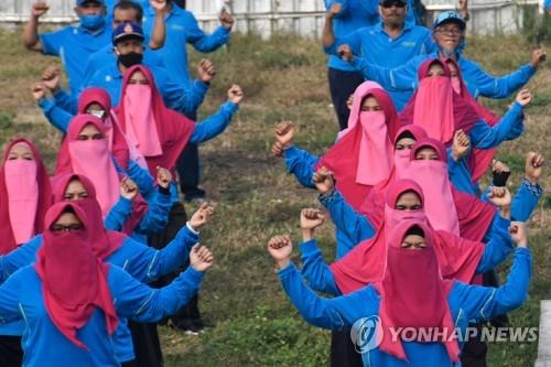 마스크 대신 니캅 착용하고 금요 운동조회 참석한 롬복섬 여성 공무원들 [AFP=연합뉴스]