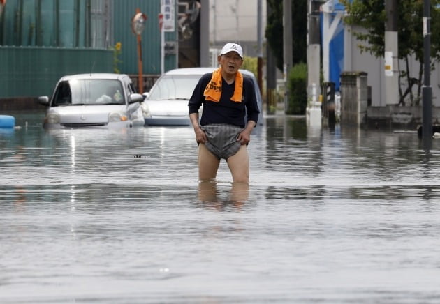 노인이 홍수로 불어난 길을 걷고 있다 [사진=EPA 연합뉴스]