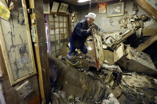 침수된 집서 약 찾는 日 주민 : 일본 남부 구마모토현 히토요시에서 12일 한 주민이 홍수로 침수 피해를 입은 집 안에서 가구를 치우며 평소 복용하던 약을 찾고 있다.  AP 연합뉴스