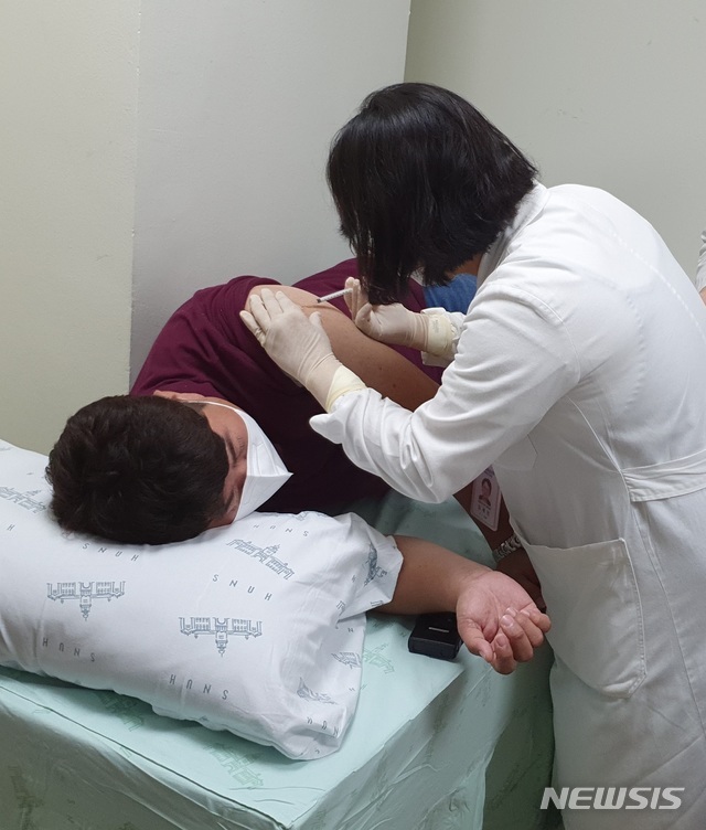 [서울=뉴시스] 서울대병원은 15일 코로나19 백신 후보물질(INO-4800)을 국내 최초로 피험자에게 투여했다고 밝혔다. 사진은 40세 피시험자에게 백신을 투여하는 의료진의 모습(사진 : 서울대병원 제공). 2020.7.15