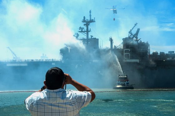 미국 시민이 미 해군의 강습상륙함인 본험 리처드함(LHD 6)의 화재 진압 작업을 쌍안경으로 지켜보고 있다. [미 해군 제공]