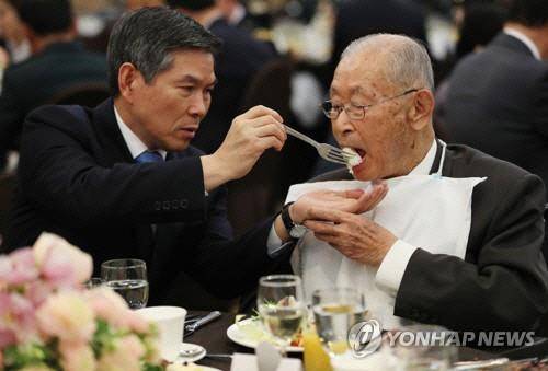 미8군 사령부가 2019년 백선엽 전 육군 대장의 99세 생일을 맞아 열어준 깜짝 생일파티에서 정경두 국방장관이 식사를 도와주고 있다.연합뉴스