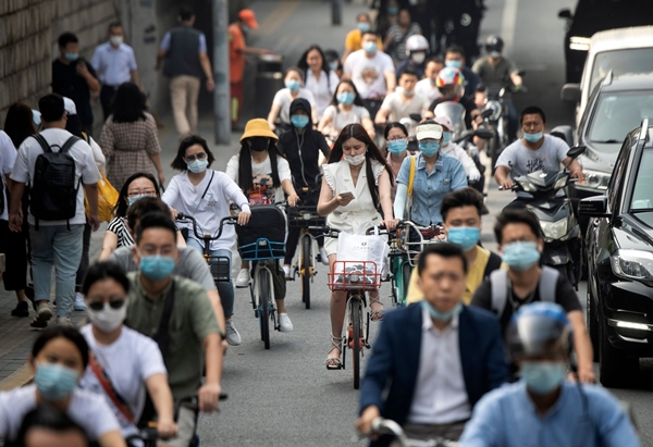 20일 중국 베이징의 한 거리에서 마스크를 쓴 시민들이 자전거로 출근하고 있다. AFP 연합뉴스