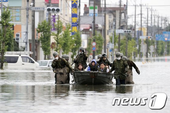 7일 일본 후쿠오카현 오무타시에서 자위대원들이 폭우로 고립된 일가족을 구출하고 있다. © 로이터=뉴스1