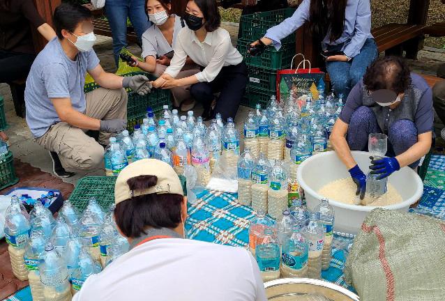 탈북자 단체인 큰샘 관계자들이 지난달 18일 서울 강남구의 한 공원에서 북으로 보낼 쌀을 페트병에 담고 있다. 뉴스1