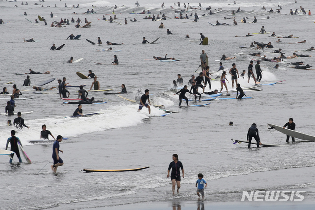 [가나가와=AP/뉴시스]일본이 '바다의 날'로 휴일을 맞은 지난 23일 가나가와현 후지사와의 해변에서 사람들이 서핑을 즐기고 있다. 2020.07.24.