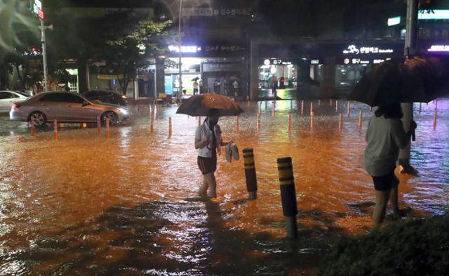 부산지역에 호우경보가 내려졌던 지난 23일 오후 부산 해운대구 센텀시티에서 시민들이 물바다가 된 인도를 걷고 있다. 부산=연합뉴스