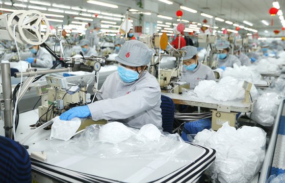 중국 산둥성 칭다오의 한 마스크 공장에서 근로자들이 마스크 생산 작업에 여념이 없다.[중국 신화망 캡처]