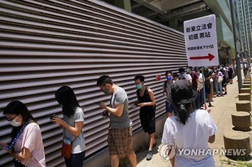 마스크 쓰고 예비선거 참여한 홍콩 유권자들 (홍콩 로이터=연합뉴스) 홍콩 범민주 진영이 12일 실시한 입법회 예비선거의 투표장 앞에 마스크를 쓴 유권자들이 길게 줄지어 서 있다.  sungok@yna.co.kr