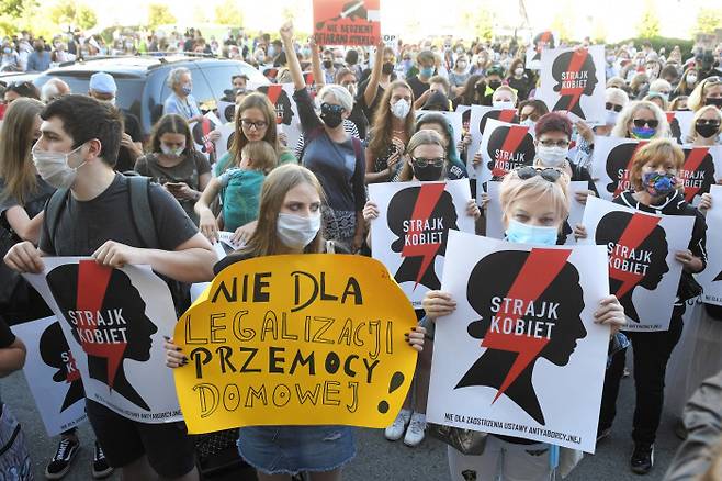 지난 7월 24일(현지시간) 폴란드 정부의 ‘이스탄불협약’ 탈퇴를 규탄하는 시위대가 수도 바르샤바에서  “가정 폭력을 합법화하고 있다” “여성 파업” 등의 문구를 쓴 팻말을 들고 있다.  / 바르샤바｜EPA연합뉴스