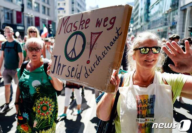 코로나19 확산 방지 조치에 반대해 두 명의 독일 여성이 '유행병의 종말-자유의 날'이라는 슬로건에 따라 시위에 참여하고 있다. © AFP=뉴스1