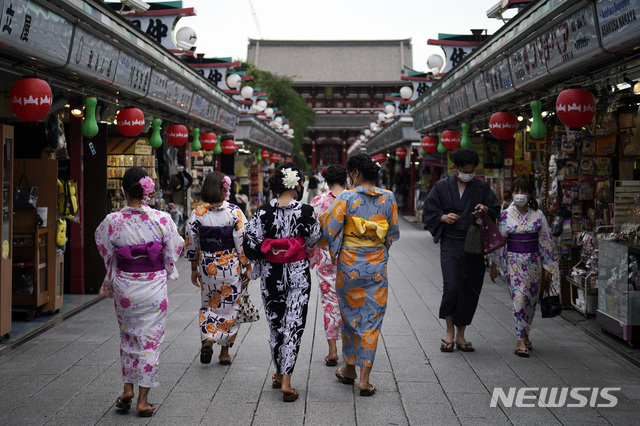 [도쿄=AP/뉴시스]27일 일본 전통 기모노를 입은 관광객들이 도쿄 아사쿠사 지구를 걷고 있다.  2020.07.27.