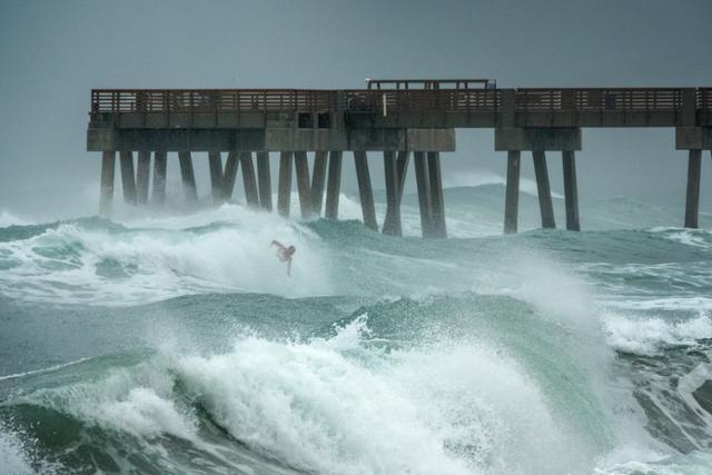 2일 미국 플로리다주 주노 비치 피어에 열대성 폭풍 이사이아스의 영향으로 거센 파도가 치고 있는 가운데 한 서퍼가 아찔한 파도를 타고 있다. 플로리다=EPA 연합뉴스