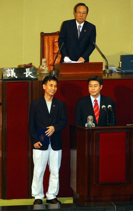고양 덕양갑 재선에서 당선한 유시민 개혁당 의원(左)이 2003년 4월 29일 캐주얼 차림으로 국회 본회의에 등원해 선서를 하려 하자 일부 의원이 복장을 문제삼아 선서가 불발되는 촌극이 빚어졌다.