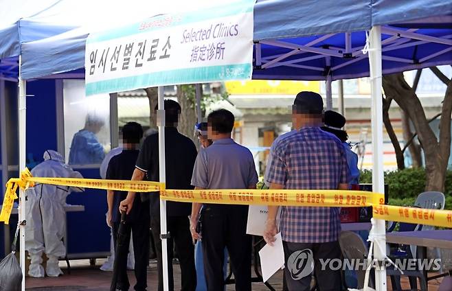 통일상가 상인 코로나19 확진 (서울=연합뉴스) 김인철 기자 = 14일 서울 중구 통일시장 앞에 마련된 신종 코로나바이러스감염증(코로나19) 임시선별진료소에서 상인과 시민들이 검사를 위해 대기하고 있다. 서울시는 통일상가에서 의류도매업을 하는 상인 부부 2명이 지난 12일 신종 코로나바이러스 감염증(코로나19) 확진 판정을 받았다고 13일 밝혔다. 2020.8.14 yatoya@yna.co.kr