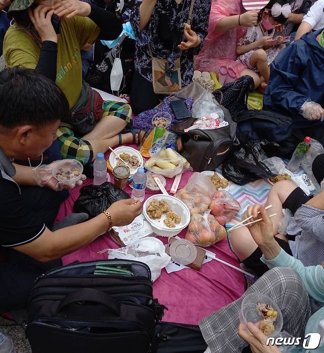 보수단체 '일파만파'가 서울 종로구 동화면세점 앞에서 개최한 집회에서 참가자들이 가져온 음식을 나눠먹고 있다. © 뉴스1